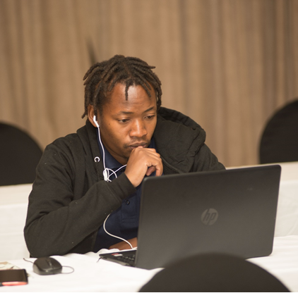 A person sitting at a table with a computer

Description automatically generated with low confidence